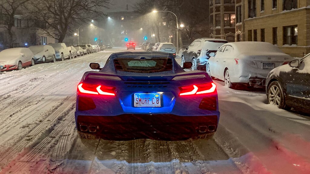 Un Corvette azul brillante visto desde atrás en una calle nevada de Chicago.