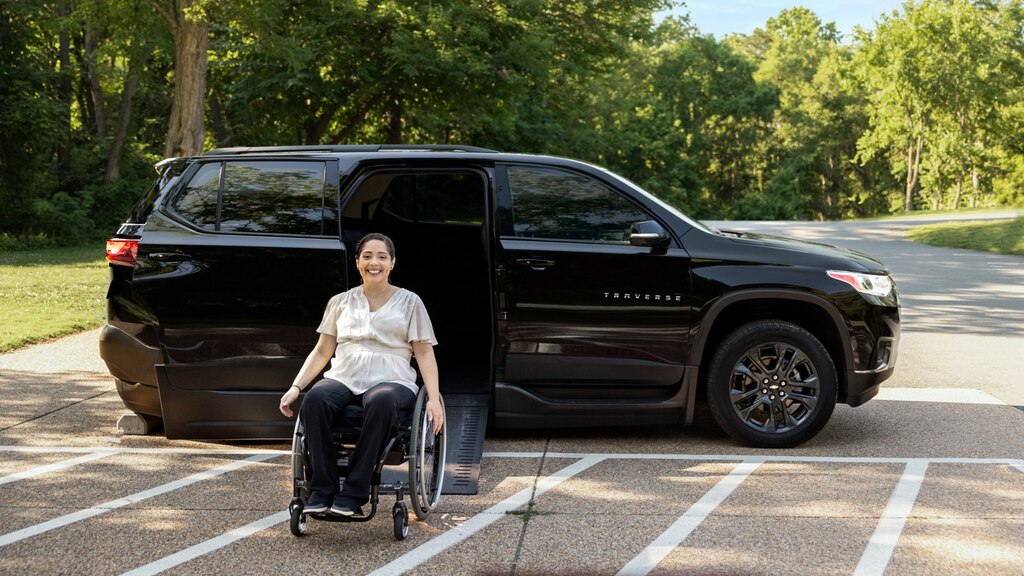 Joanna Bonilla utiliza una silla de ruedas para salir de una Chevy Traverse negra sobre una rampa.