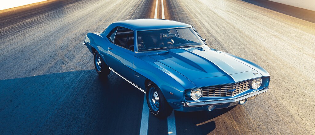 Un COPO Camaro original de color azul detenido en medio de un camino.