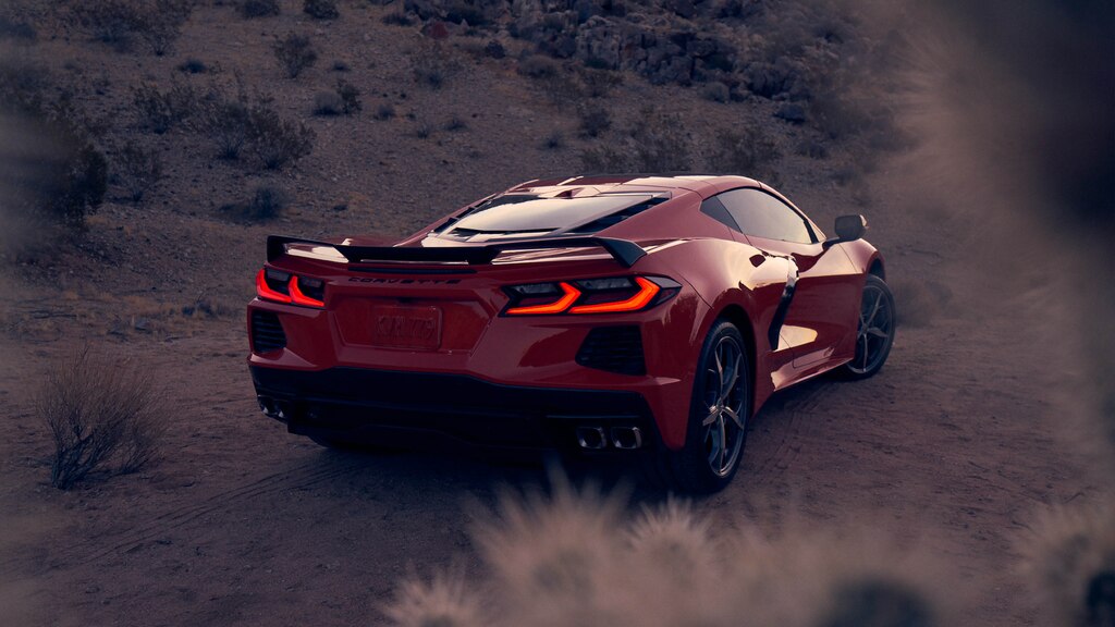 Un coupe Corvette 2020 en Rojo Antorcha en un paisaje desértico, visto desde atrás con las luces de freno encendidas.