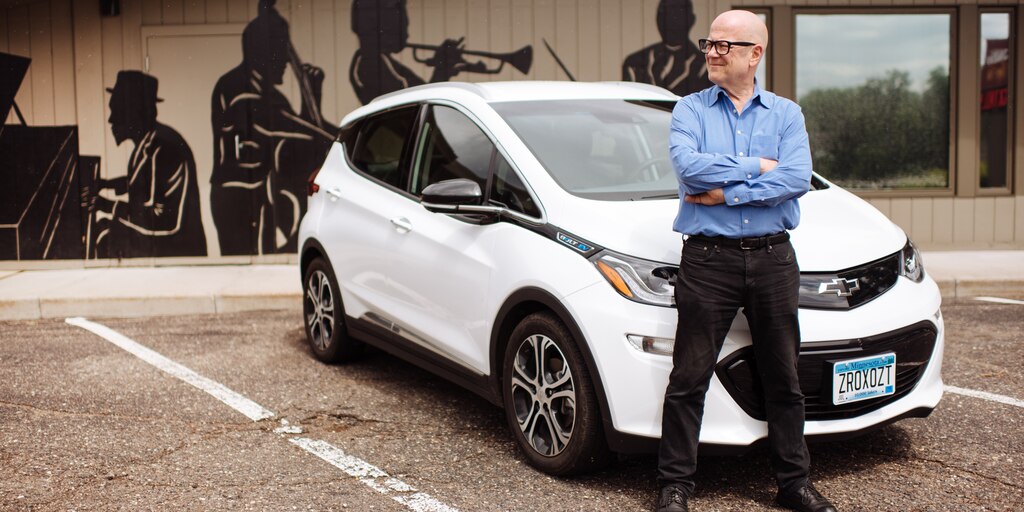 Un hombre se encuentra en frente de un Bolt EV.