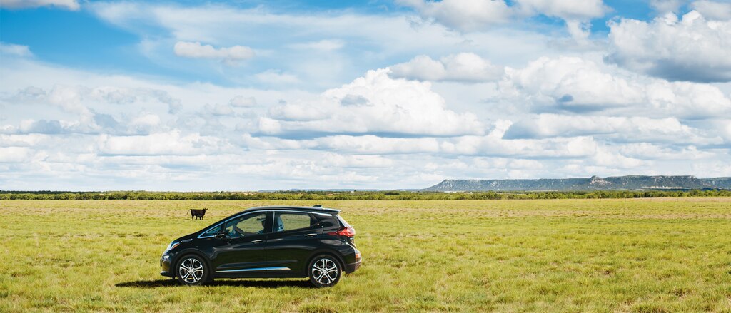 Harry Akers adentro de su Bolt EV, visto en una pastura en su rancho.