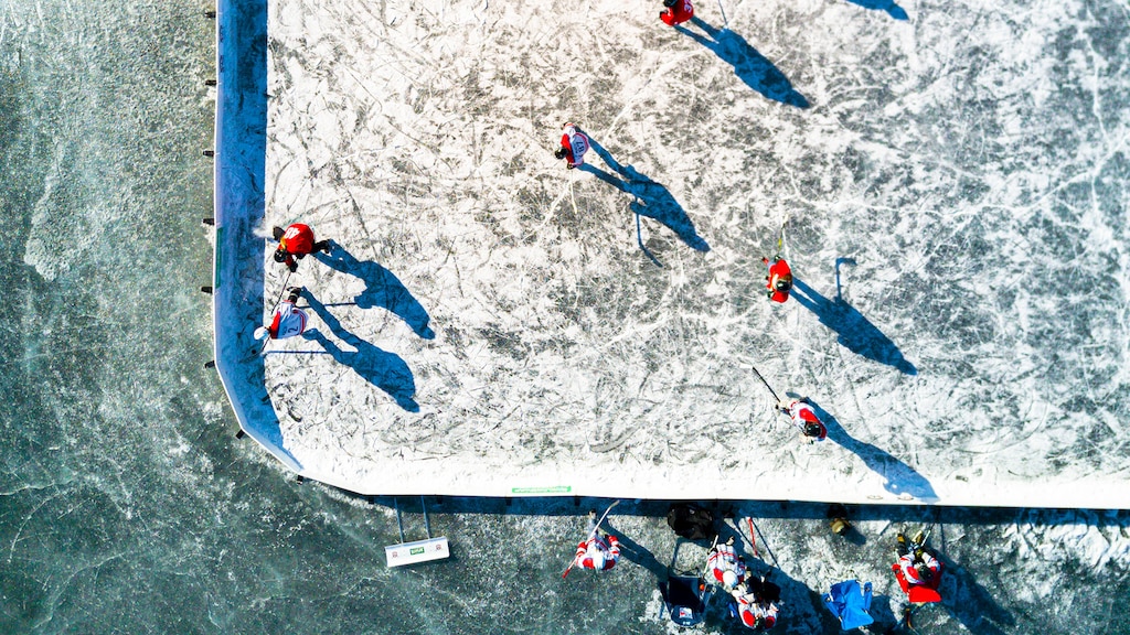 Vista aérea de un grupo de personas jugando al hockey en una cancha delimitada al aire libre.