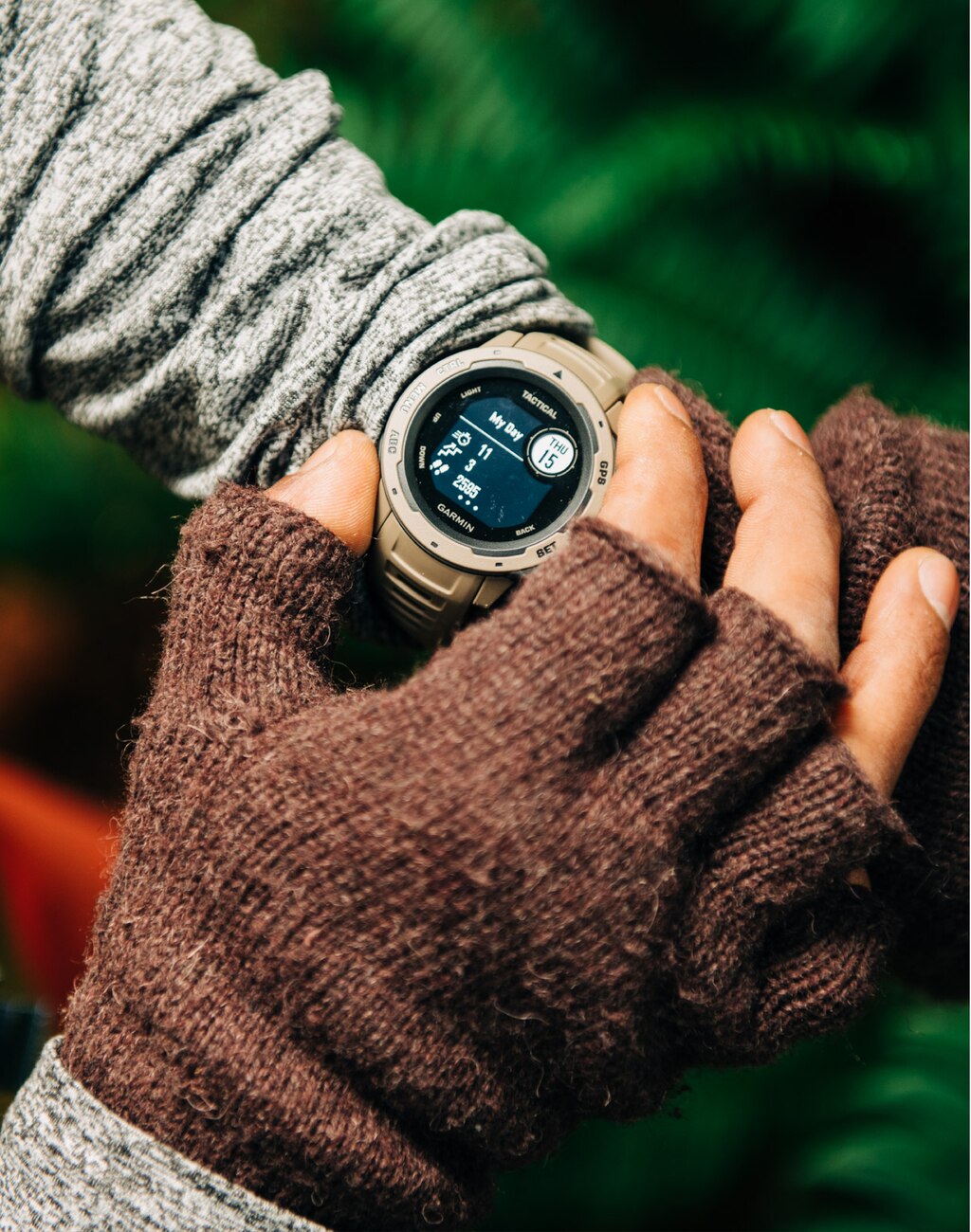 Se muestran los antebrazos y manos de una persona con un reloj inteligente Garmin Instinct en la muñeca izquierda.
