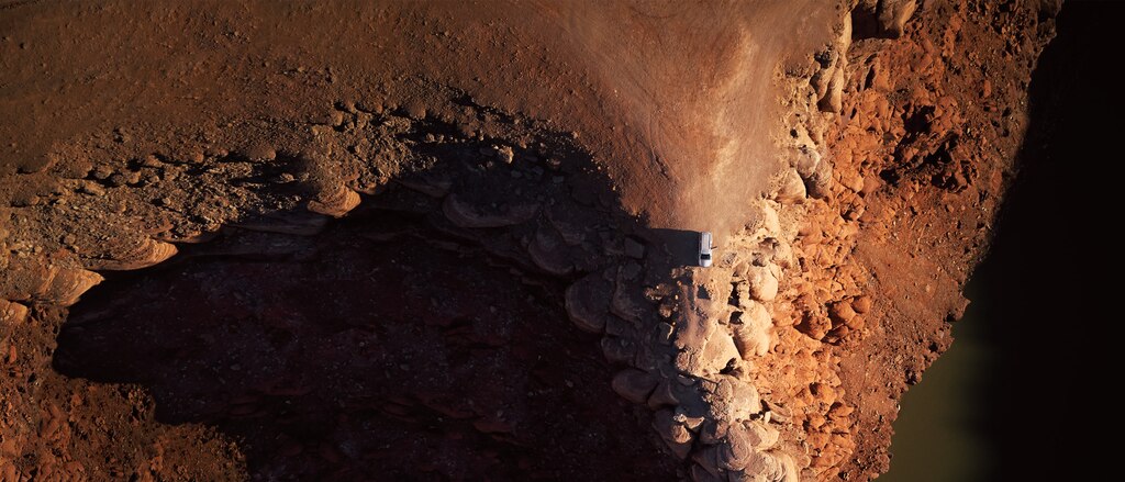 Toma aérea de una SUV Chevrolet al final de un camino en el desierto.