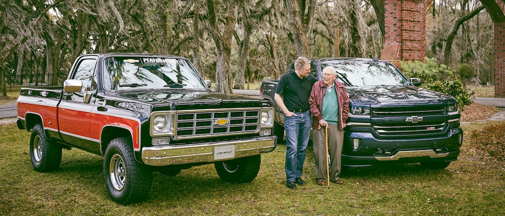 Eric Stanczak y Paul Hitch están parados hablando entre una camioneta Chevy clásica y una Chevy Silverado Centennial Edition.