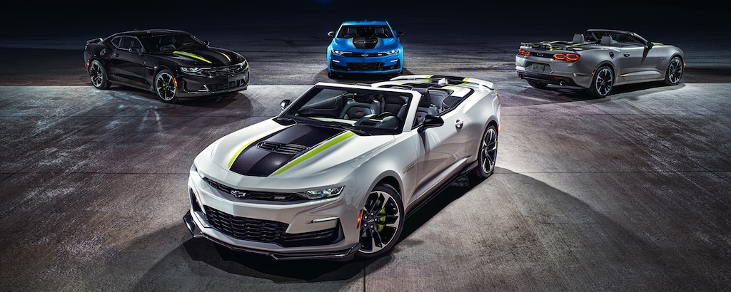 Un Camaro Blanco convertible estacionado, exhibido junto con otros tres modelos de Camaro