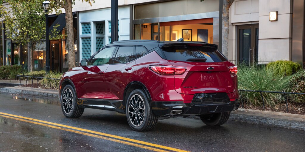 Una Chevy Blazer 2023 en Rojo Radiante Tintcoat circulando por un barrio moderno