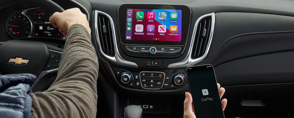 Una pareja usa la función Apple Car Play para mejorar su experiencia con la Chevy Equinox 2023
