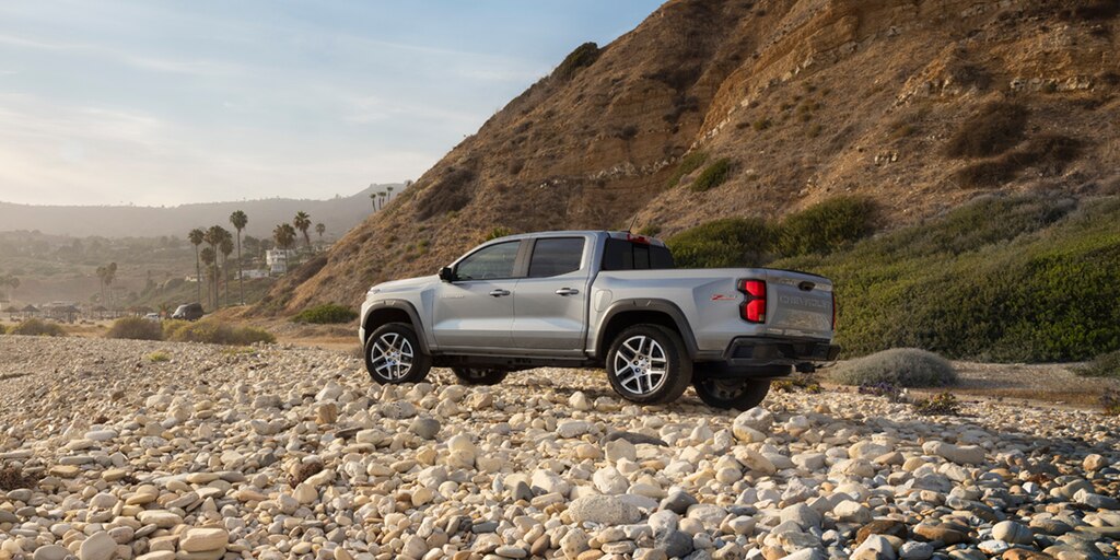 La Chevy Colorado 2023 en Acero Satinado Metálico estacionada en una costa rocosa frente al océano