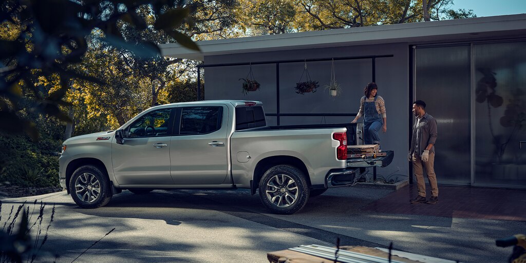 Pareja cargando suministros en la parte trasera de una Chevrolet Silverado 1500