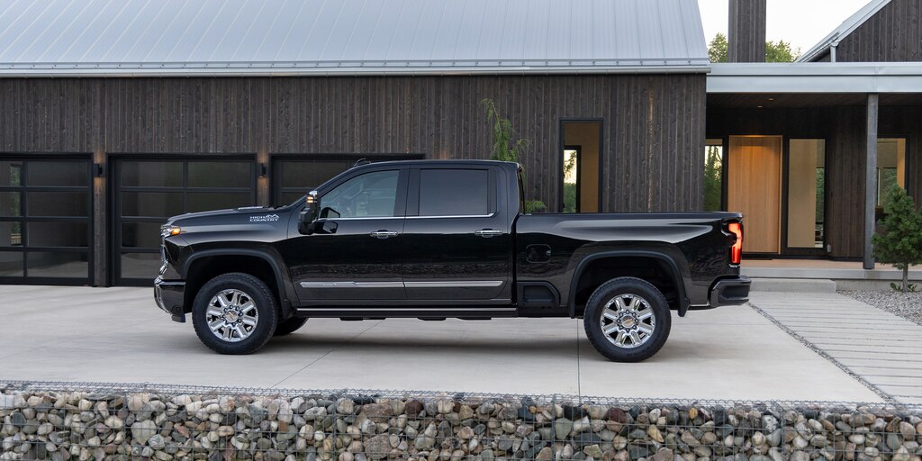 La Silverado HD 2024 en Negro exhibida fuera de una casa moderna estilo rancho