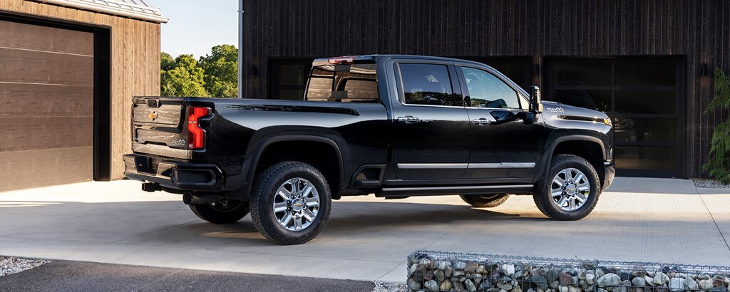 Una Silverado HD 2024 en Negro mostrada frente a una casa moderna