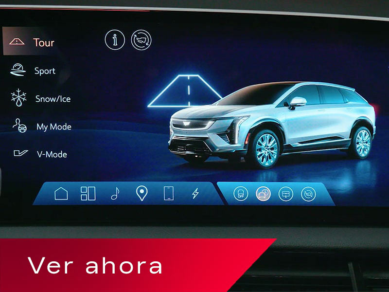 La pantalla de infoentretenimiento de una Cadillac OPTIQ, en la que se exhiben los modos de conducción al lado de una imagen renderizada de una SUV Cadillac plateada, arriba de un cartel rojo en el que se lee "Watch Now" (Mirar ahora).