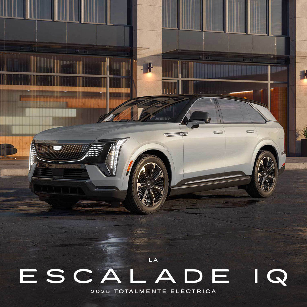 Vista de medio perfil de ESCALADE IQ 2025 estacionada al lado de un edificio industrial