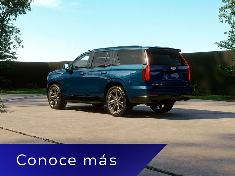 Vista trasera de medio perfil de Cadillac Escalade 2026 azul estacionada en una entrada